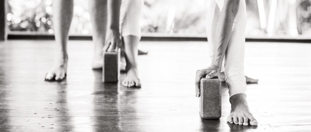 People practicing yoga or similar exercises using yoga blocks as aids 1