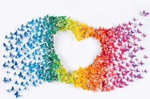 a collection of colorful butterflies arranged in a heart shape, with colors grading from blue to purple