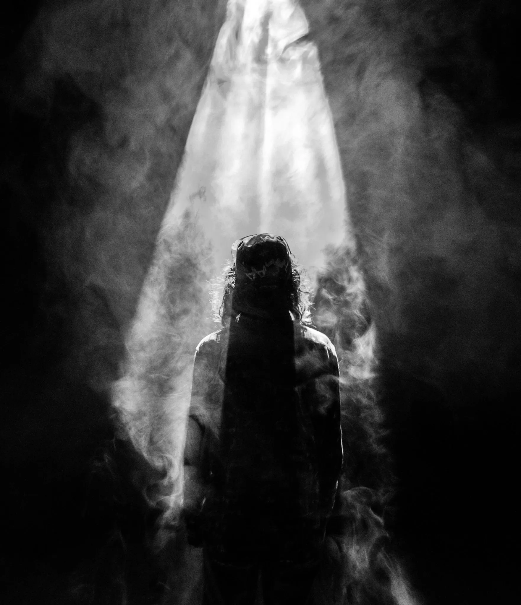 silhouette of a person standing in a room with fog
